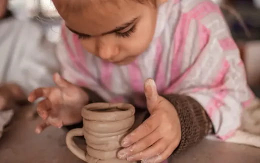 a baby holding a cup