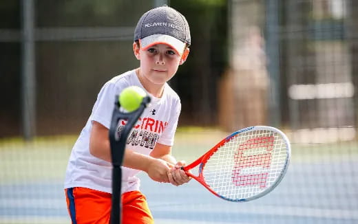 a young boy playing tennis