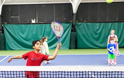 a kid playing tennis