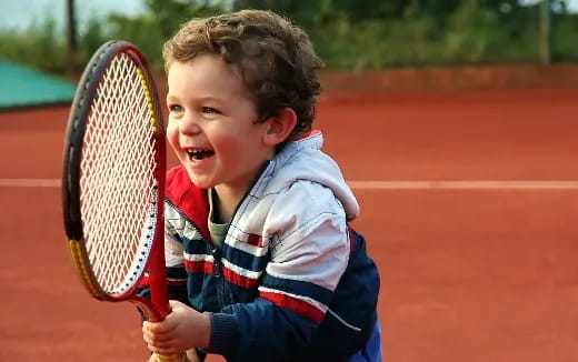 a young boy playing tennis