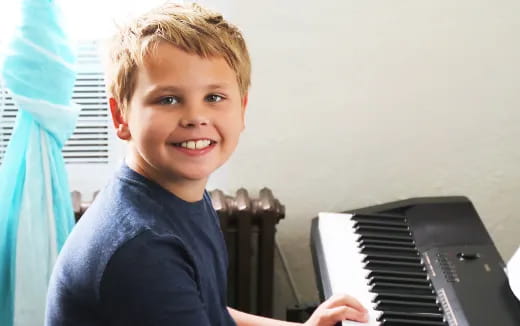 a boy playing a piano