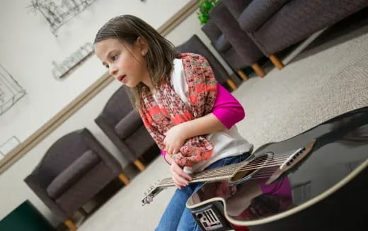 a girl playing a guitar