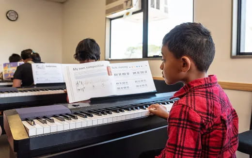 a boy playing a piano