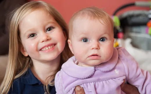 a girl holding a baby